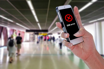 Man using SIM ERROR smartphone at airport and blurry background with clipping path on screen panel