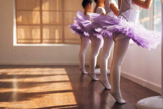 Children practicing ballet poses in ballet studio