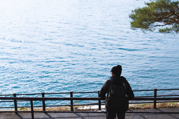 Young man in a overcoat looking at views of the lake winter in Japan