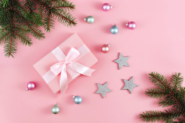 Christmas background with decorations gift box and snowflake on pink table.