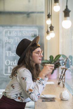 Stylish Girl Sitting At The Cafe Drinking Tea