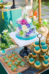 Colorful cream cakes, cookies, donuts on dessert tables.