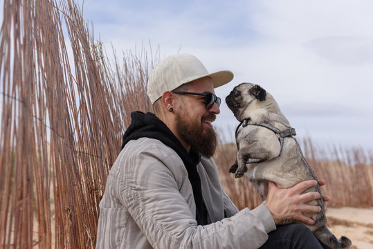 Cheerful man sitting with pug