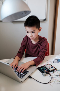 Boy working on an electronic DIY kit at home