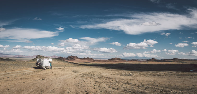 panorama shot of a camping truck in mongolian desert