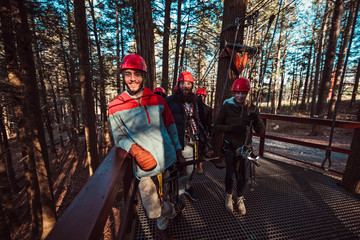 Friends pose on an outdoor deck before starting their zip line adventure