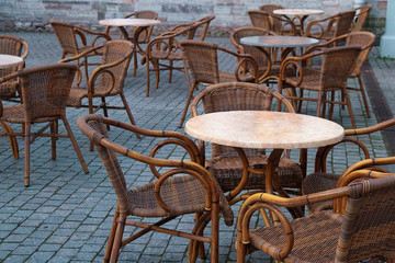 stone table and wooden chairs of street cafe