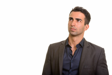 Portrait of young handsome Persian businessman thinking