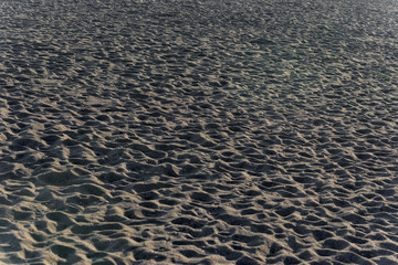 Closeup photo of dirty sandy beach texture background