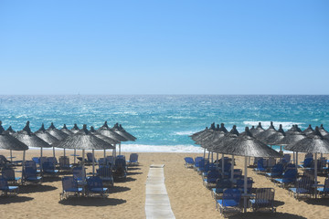 Beach umbrellas and sunbeds on Greece. Summer beach with parasols
