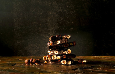 Black chocolate with nuts  on dark background. Copy space, closeup
