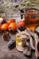 Bottles with emulsion, stones, dry herbs and wooden details. Occult, esoteric, divination and wicca concept. Mystic, old apothecary and vintage background