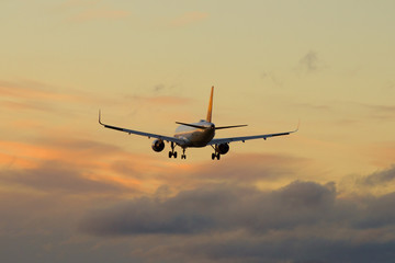 A passenger aircraft flies into the evening sky