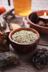 Healthy tea, dry herbs, plants, candle and stones on wooden table. Homeopathy and herbal alternative medicine.