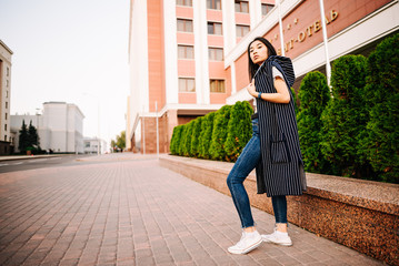 young beautiful asian girl outdoors, woman in urban environment