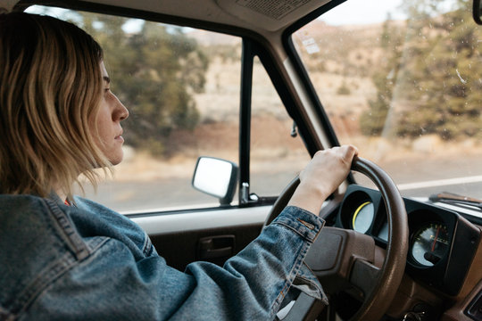 Young female drives vintage truck in wilderness environment