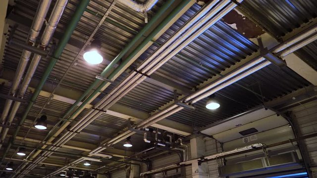 Industrial heating pipes under ceiling or another household communications pipelines in modern plant. 