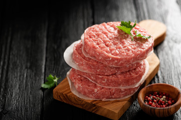 Raw Ground beef meat Burger steak cutlets  on dark wooden background.