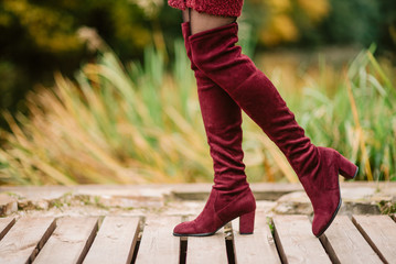 Female legs in knitted red boots. Girl in beautiful shoes outdoors