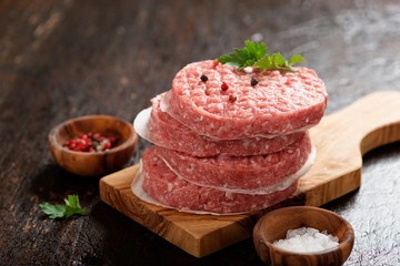 Raw Ground beef meat Burger steak cutlets  on dark wooden background.
