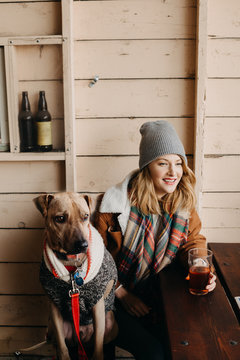 Woman Sitting At A Brewery With Her Dog