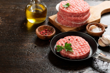 Raw Ground beef meat Burger steak cutlets  on dark wooden background.