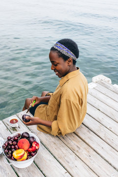 Woman cutting stone fruit on the dock
