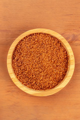 An overhead photo of a bowl of brown sugar, shot from above on a rustic wooden background with a place for text