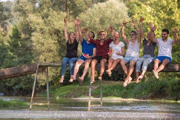 friends enjoying watermelon while sitting on the wooden bridge