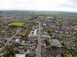 Aerial photo taken over Leeds showing houses, streets, paths and fields, taken in West Yorkshire