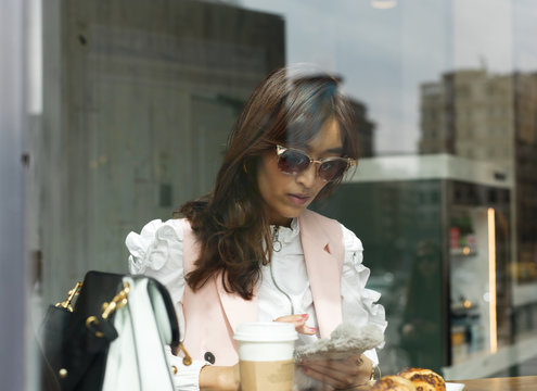 Elegant woman relaxing with phone having lunch