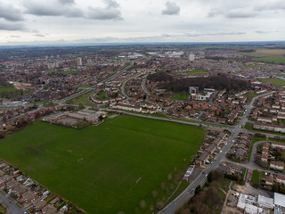 Aerial photo taken over Leeds showing houses, streets, paths and fields, taken in West Yorkshire