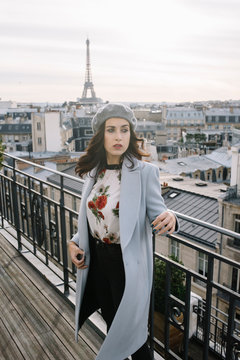 Young woman on a balcony with the Eiffel tower view