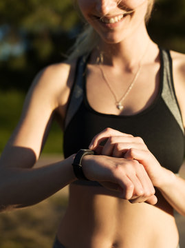 Crop content sportswoman using smartband