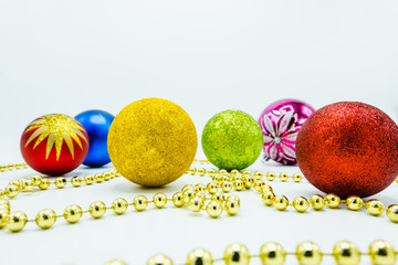 Red, green, gold, blue and pink christmas balls and a golden chord.