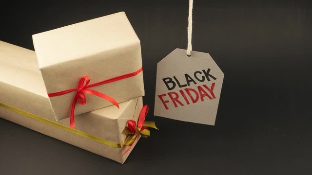 Two gift boxes and promotional sign of black Friday on the black background
