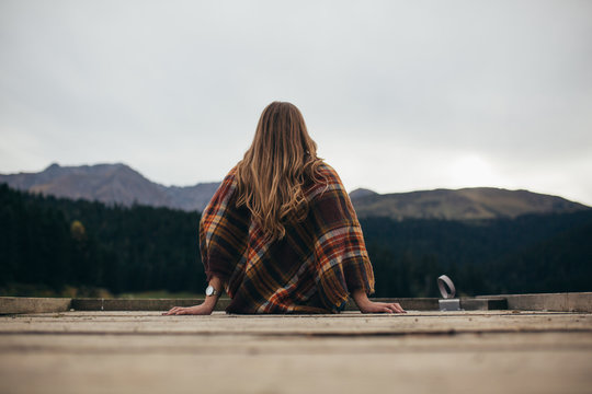 Young woman enjoying at lake on autumn day.