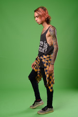Studio shot of rebellious young man against green background