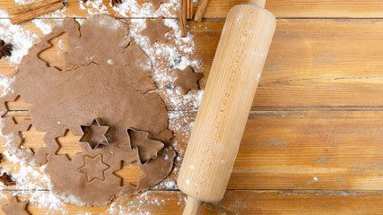 Christmas gingerbread cookies: Gingerbread dough, baking shapes and kitchen utensils on wooden table