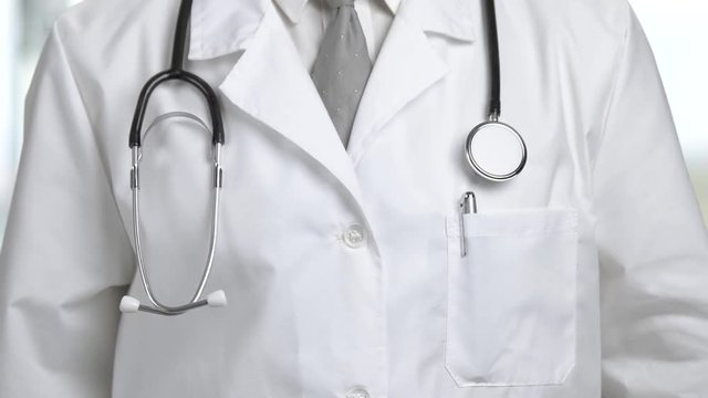 Close up doctor with stethoscope. Male doctor adjusting his stethoscope close up. Medicine and healthcare concept.