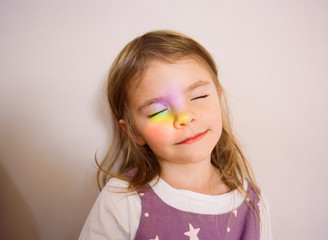 Portrait of a girl with rainbow light on her face