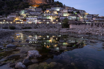 City view of Berat Albania houses, with reflection in river at dusk