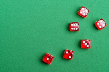 group of red dice on a green table are in a casino