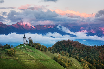 Beautiful sunrise landscape of church Jamnik in Slovenia with cloudy sky - obrazy, fototapety, plakaty