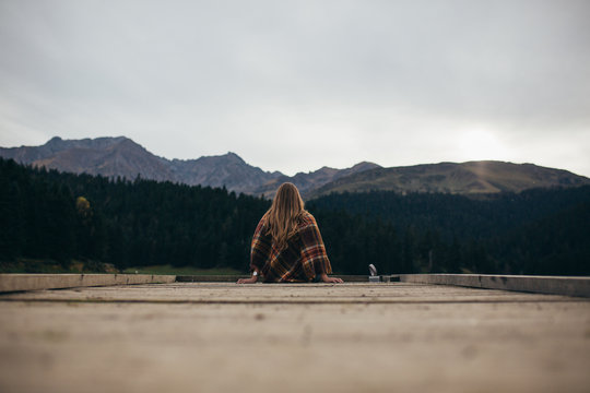 Young woman enjoying at lake on autumn day.