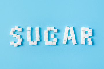 sugar inscription made of sugar cubes isolated on trendy blue background. Top view. World diabetes day