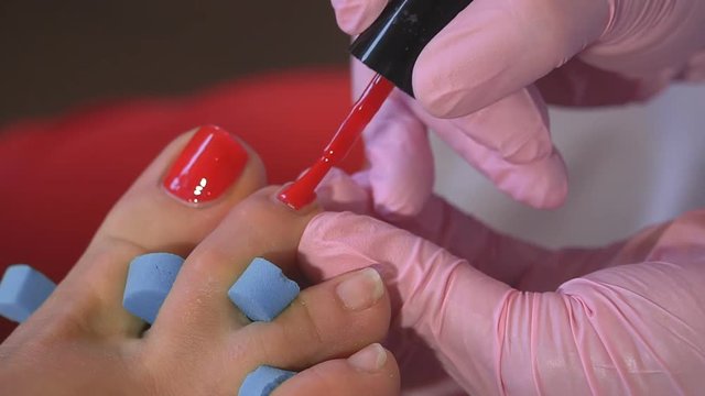 Pedicures in the salon. The master cares for the nails and feet of the client, doing the pedicure. Peeling feet pedicure procedure