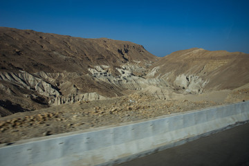 Curvy road with a view on Dead Sea at the end of a Summer day in Negev Desert