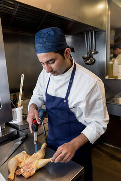 Man roasting chicken with torch