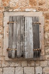 Old retro wooden shutters on window. Old stone house. Exterior detail. Wooden window.